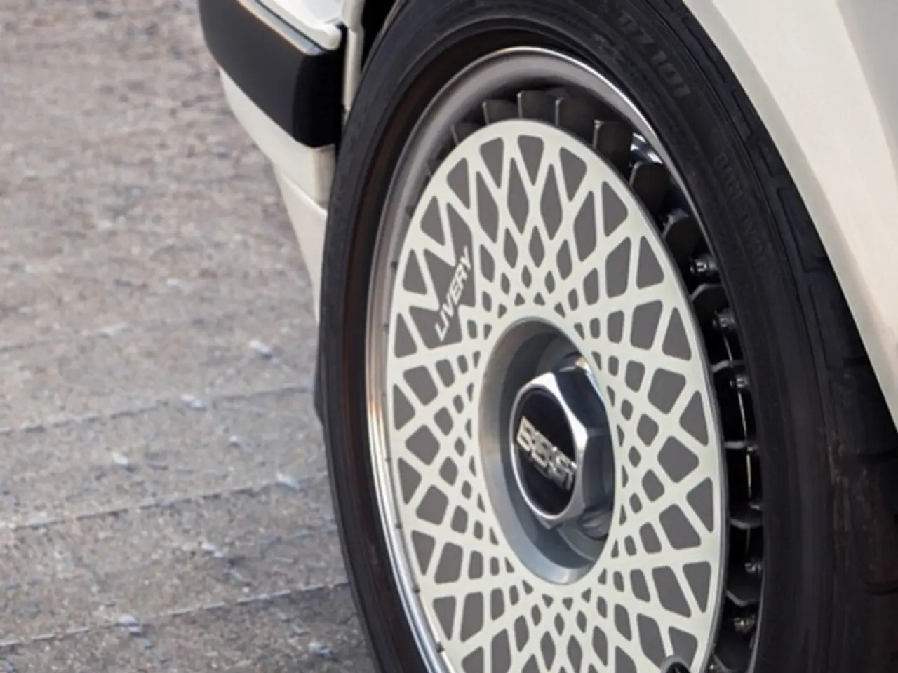 In this image I can see a vehicle tyre on the grey color surface.