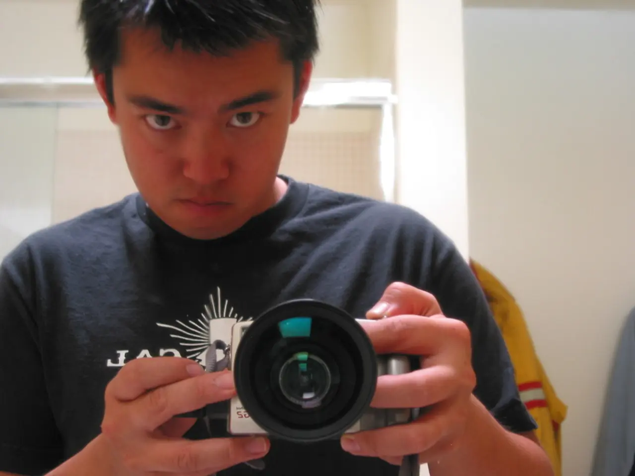 This is a picture taken in a mirror. In this picture there is a person holding camera. In the...