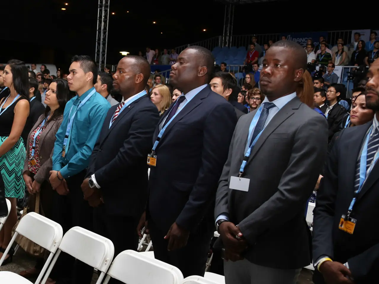 In this image we can see these people wearing blazers and identity cards are standing on the floor...