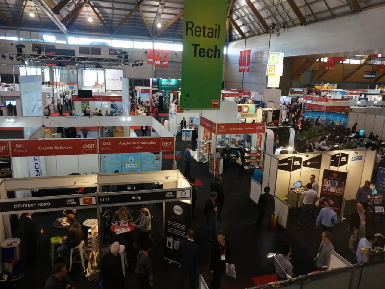 In this image we can see persons, stores, chairs, tables, computers, advertisements, tents, lights...