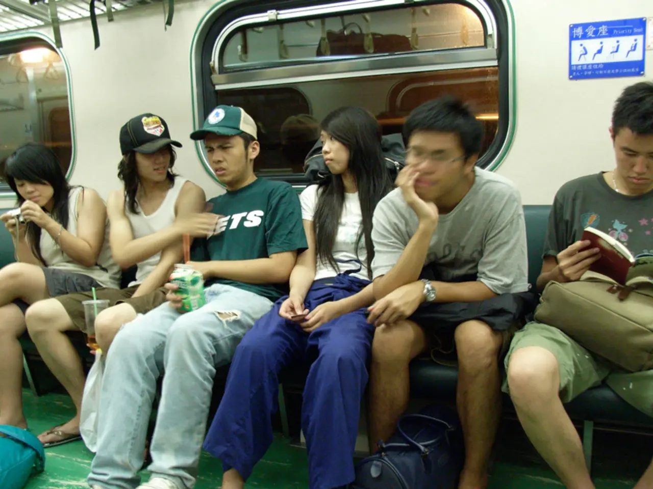 In this image we can see these people are sitting on the seats inside a metro train. In the...