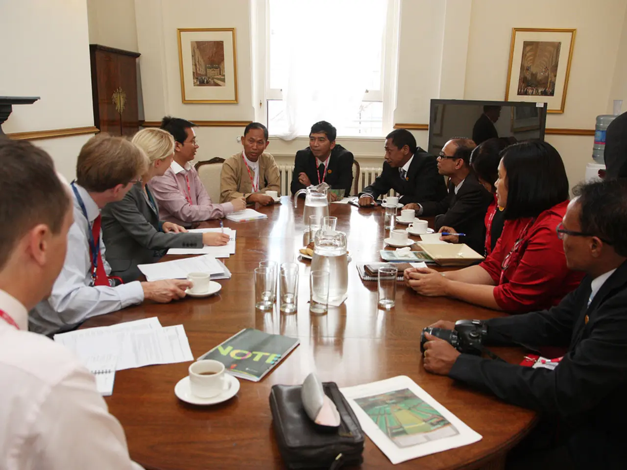 In this picture we have a conference like round table, here we can see some people sitting around a...