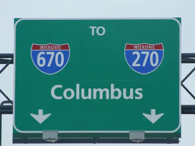 In this image we can see a green color signboard with some numbers and text written on it, and it...