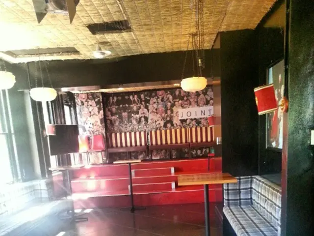 The image is clicked inside a room. In the foreground of the picture there are tables, couches and...