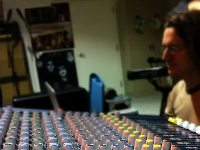 In this picture we can see an electronic device. There is a person. We can see a few objects in the...