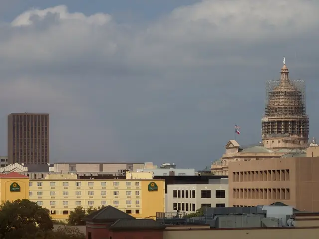 In this image I can see number of buildings and on the bottom left side of this image I can see...
