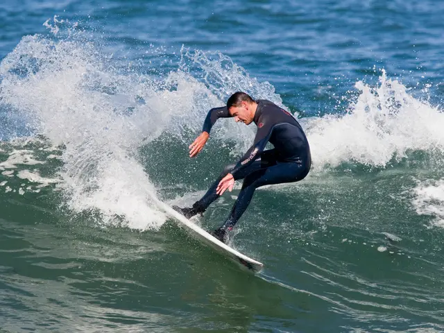 In this image we can see a person surfboarding in the water.
