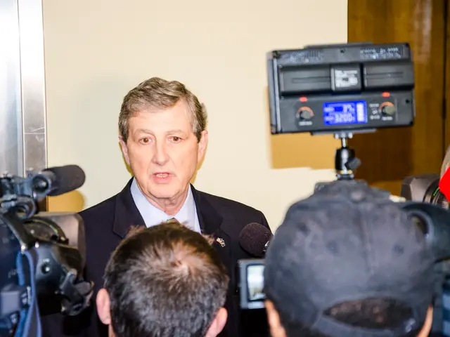 In this picture I can see few people in front who are holding cameras and mics and I see a man in...